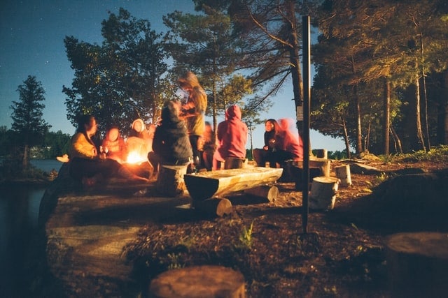 Group of people at campfire near 5 man tents