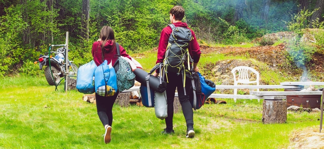 Couple going motorbike camping with swag