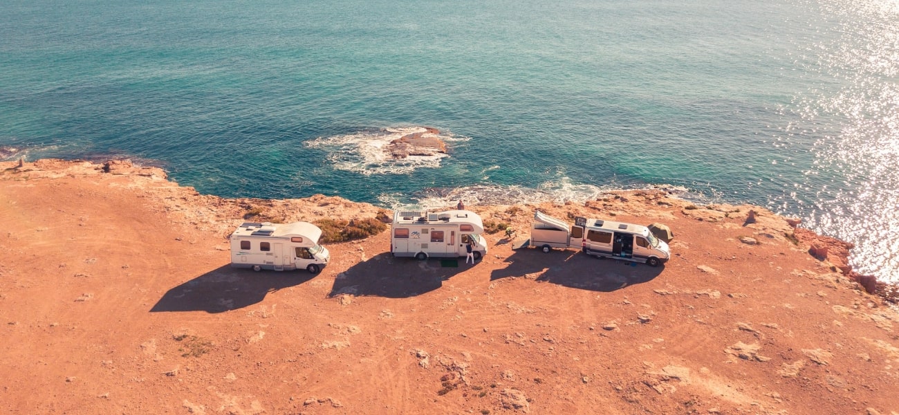 Caravans in sun by cliff