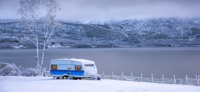 Caravan by lake in snow
